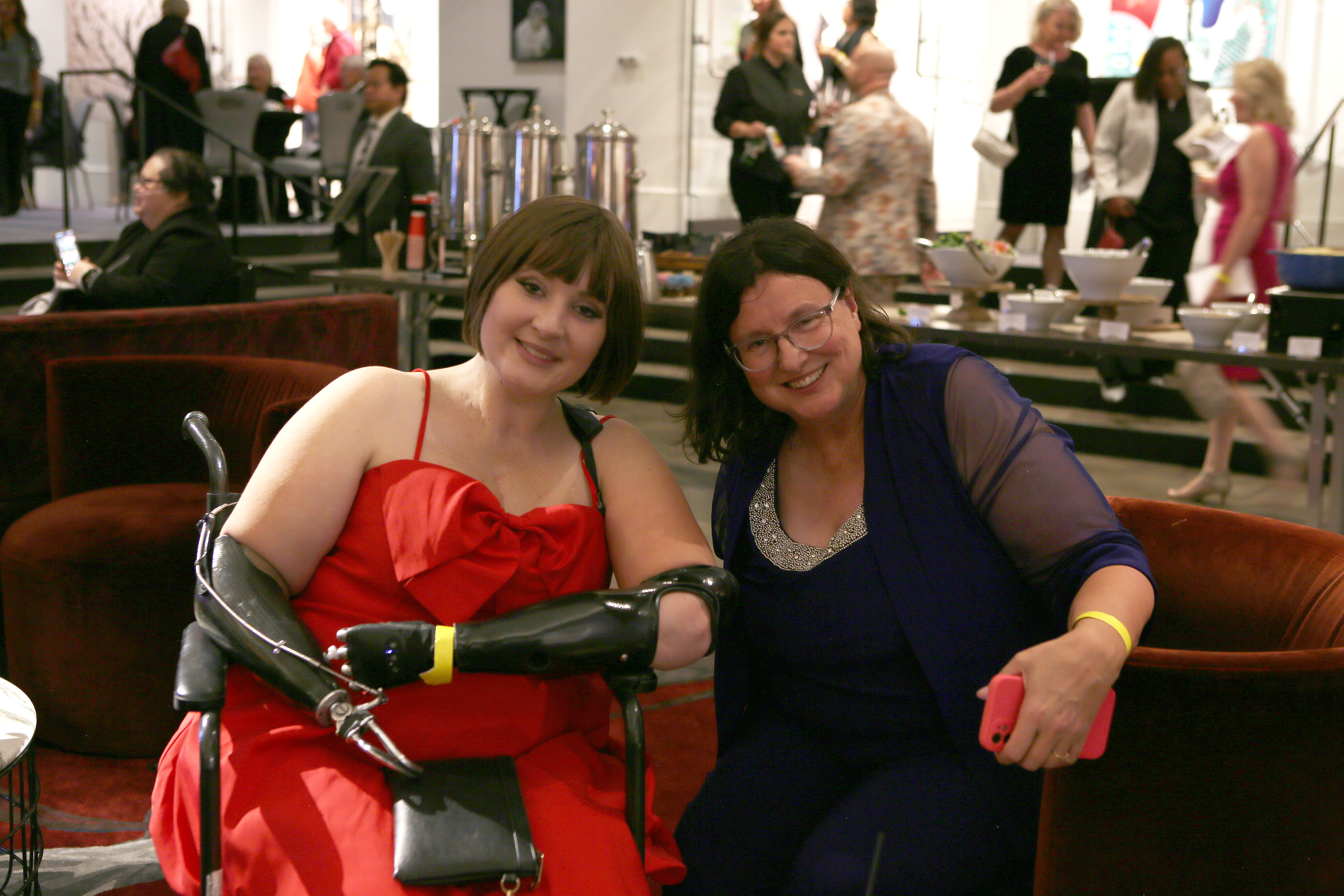 Two women pose for a picture in lobby.